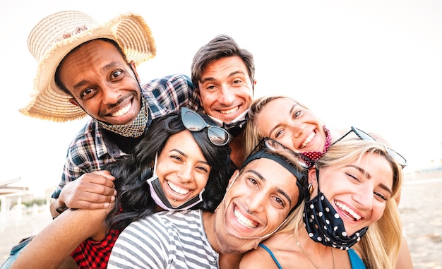 Gemischtrassige Freunde nehmen Selfie lächelnd über offene Gesichtsmasken