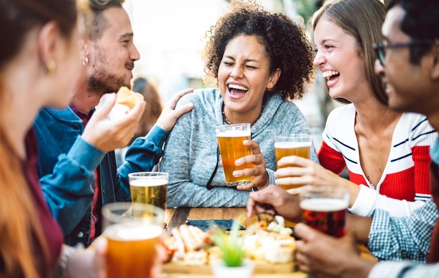 Gemischtrassige Freunde trinken Bier im Brauerei-Pub-Garten