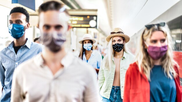 Gemischtrassige Gruppe, die mit ernstem Gesichtsausdruck am Bahnhof geht