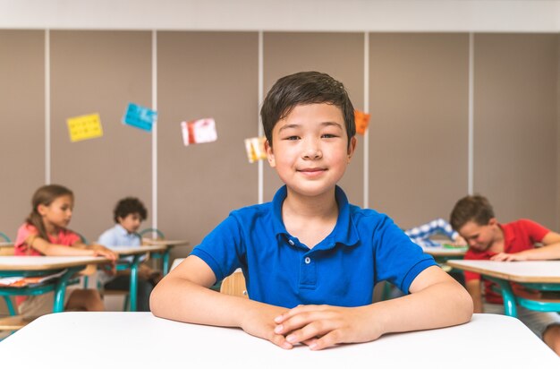 Gemischtrassige Gruppe von Kindern in der Grundschule - Spielerische Schüler, die die Schulzeit und den Unterricht mit Lehrer und Klassenkameraden genießen