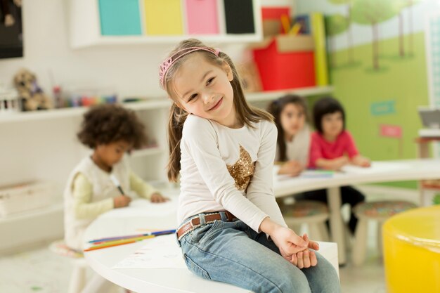 Foto gemischtrassige kinder, die in das spielzimmer zeichnen