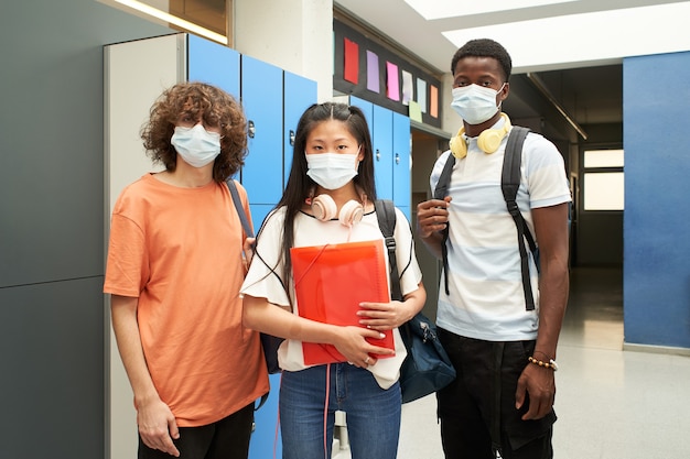 Gemischtrassige Studenten, die Masken tragen, um die Ausbreitung des Coronavirus-Lebensstils der M...