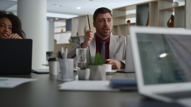 Gemischtrassige Unternehmensgruppe bespricht Geschäftsentwicklungsprojekt bei Bürobesprechung. Brainstorming im Team verschiedener Mitarbeiter, Gespräch über Finanzberatungsplan, Kommunikationskonzept für Unternehmensteamarbeit