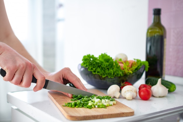 Gemüse auf Schneidebrett für frischen Salat an der Küche zu Hause hacken