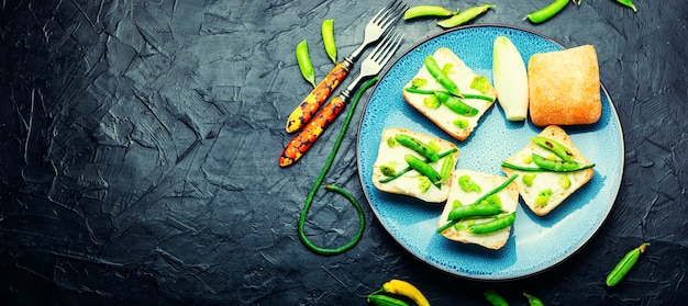 Gemüse-Bruschetta mit Kohl, grünen Erbsen und Spargelbohnen. Platz kopieren