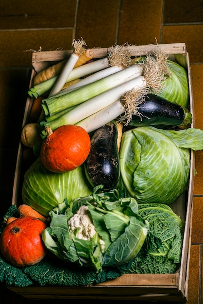 Foto gemüse in einer kiste nahe dem hintergrund kohl karotte aubergine lauch kürbis