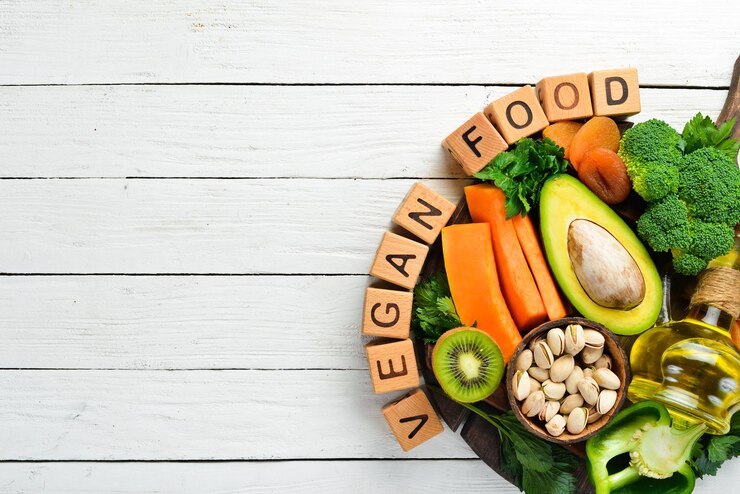Foto gemüse, obst und nüsse, avocado, brokkoli, pistazien, kürbis, getrocknete früchte, sellerie, gurke und kiwi. die aufschrift vegan food draufsicht rustikaler stil