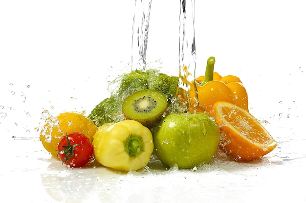 Gemüse und Obst mit Spritzwasser auf weißem Hintergrund