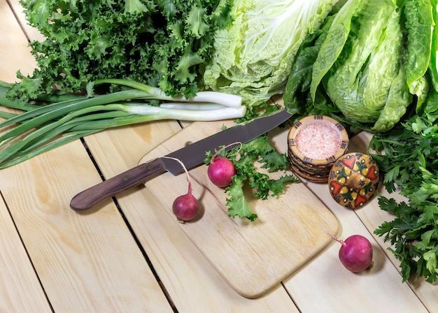 Gemüse Verschiedene Arten von Salat Petersilie Radieschen Frühlingszwiebeln auf einem Holztisch in der Nähe