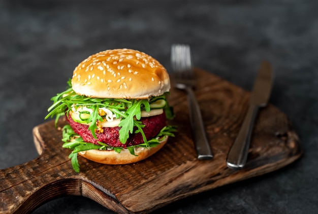 Gemüseburger mit Rüben, Kichererbsen, Birne, Rucola, Gurke auf einem Schneidebrett