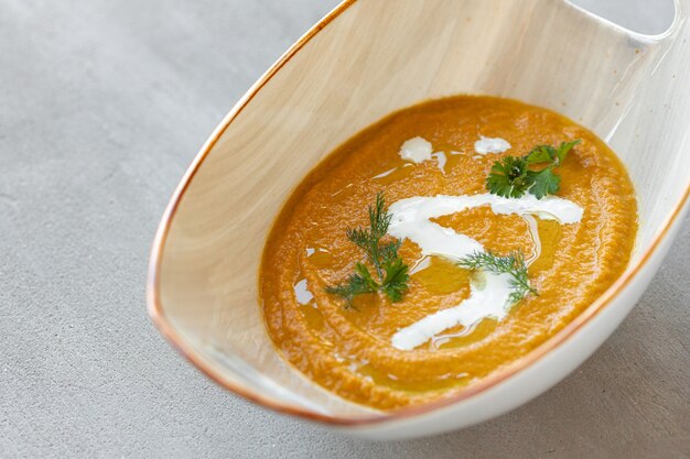 Gemüsecremesuppe in Schüssel auf grauem Tisch