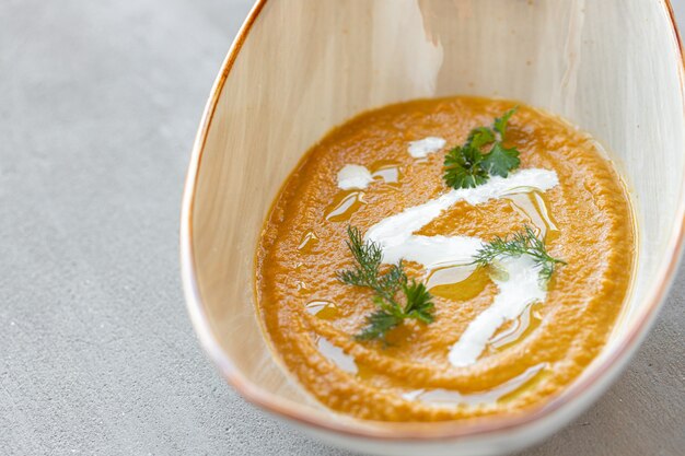 Gemüsecremesuppe in Schüssel auf grauem Tisch