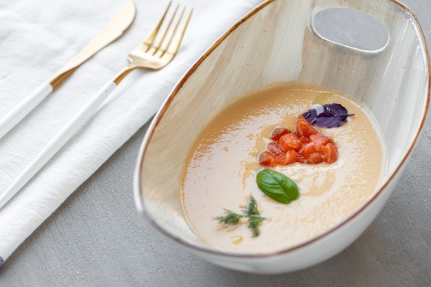 Gemüsecremesuppe in Schüssel auf grauem Tisch