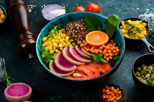 Gemüsediät Salat Quinoa Spinat Mais Tomaten und Rettich Wassermelone Schüssel Buddha Veganes Essen Draufsicht Auf einem Steinhintergrund