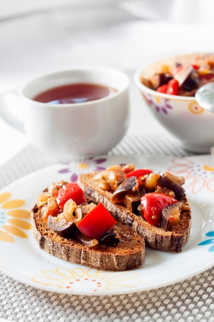 Gemüseeintopf mit Auberginen, Paprika und Tomaten auf geröstetem Roggenbrot