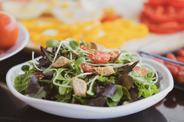 Gemüsesalat in weißem Teller mischen