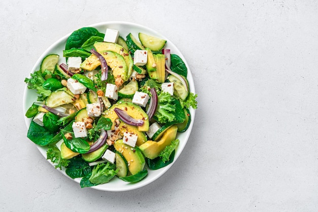 Gemüsesalat mit Avocado-Gurken-Feta und Kräutern, gewürzt mit Nüssen und Sesamsamen und Flachs