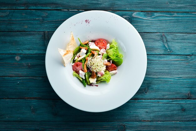 Gemüsesalat mit Brie-Käse, Kirschtomaten und Spinat In der Platte Draufsicht Freier Platz für Ihren Text Rustikaler Stil