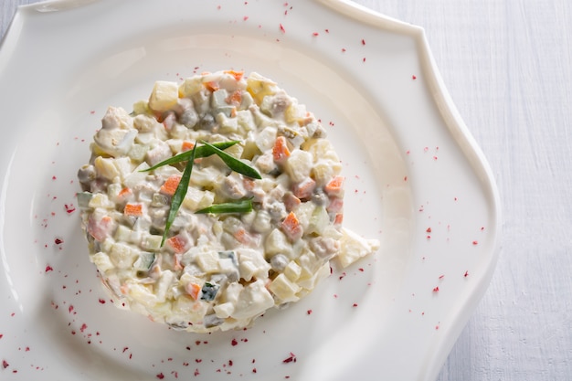 Gemüsesalat mit grünen Erbsen und Kräutern auf weißer Platte