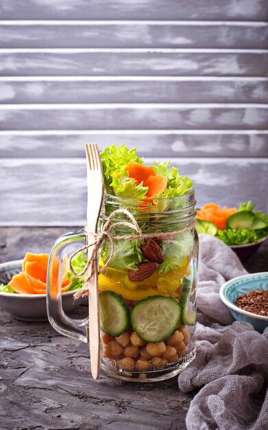 Gemüsesalat mit Gurke, Pfeffer, Mandel und Kichererbse im Glas.