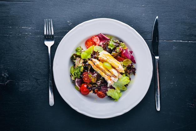 Gemüsesalat mit Huhn und Mangosauce auf einem hölzernen Hintergrund Draufsicht Freier Platz für Text