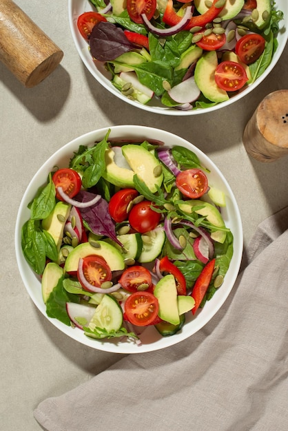 Gemüsesalat mit Tomaten, Avocado und Gurke auf grauem Hintergrund