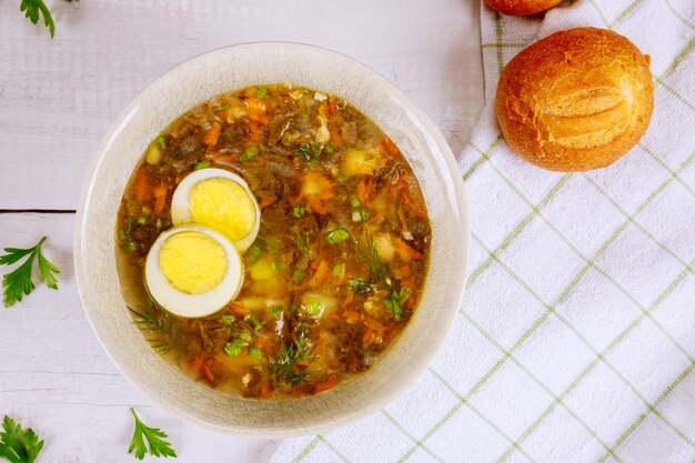 Gemüsesuppe mit Ei und knusprigen Brötchen