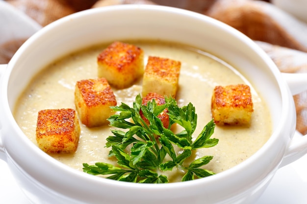 Gemüsesuppe mit gerösteten Brotstücken und Petersilie.