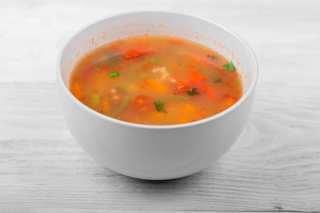 Gemüsesuppe mit geschnittenen Karotten, Paprika, Tomaten, Bohnen und Reis