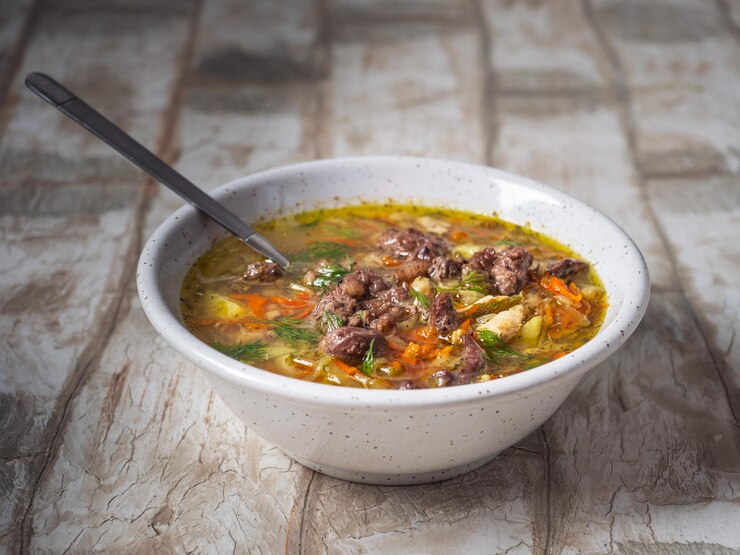 Foto gemüsesuppe mit hühnerbrühe und hühnerleber auf einem tiefen teller