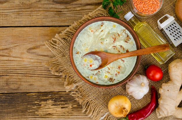 Gemüsesuppe mit Linsen in Tonschale auf Tisch