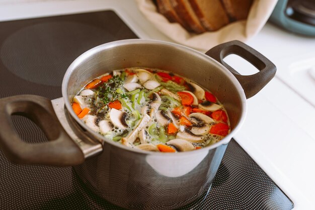 Gemüsesuppe mit Pilzen, Karotten und Zwiebeln in einem Topf