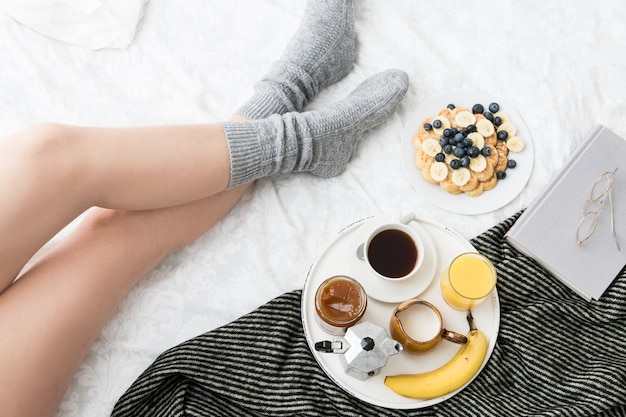 Gemütliche Frühstücksszene im Bett an einem Wochenende mit Kaffee und Waffeln