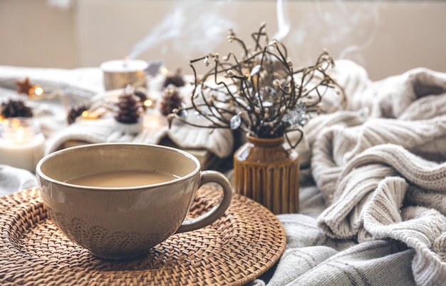 Gemütliche Herbstkomposition mit einer großen Tasse Kaffee im Bett
