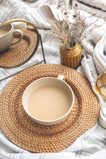 Gemütliche Herbstkomposition mit einer Tasse Kaffee und Kerzen im Bett