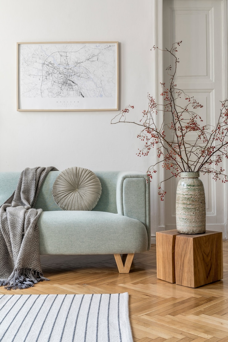 Foto gemütliche und kreative komposition aus stilvoller wohnzimmereinrichtung mit rahmen, grünem sofa, holzmöbeln, pflanzen und accessoires. weiße wände, parkettboden.