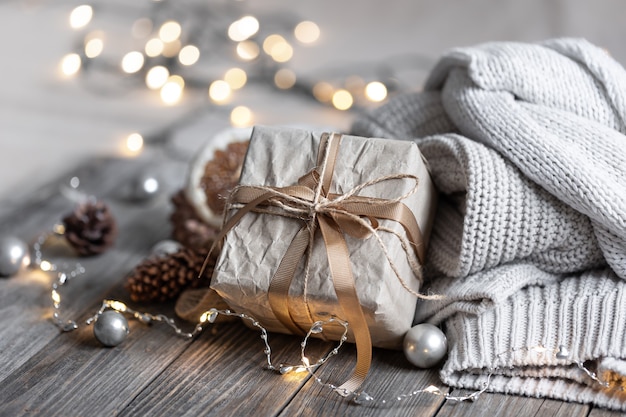 Gemütliche Weihnachtskomposition mit einer Geschenkbox auf unscharfem Hintergrund in Bokeh