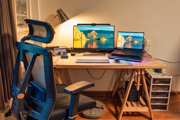 Gemütlicher moderner Home-Office-Arbeitsraum mit Arbeitsgerät und warmem Licht im Schlafzimmer