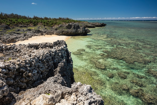 Gemütlicher Strand mit smaragdgrünem Meer voller Korallenriffe, gesehen von der Spitze der Samurai-Familienruinen Japan