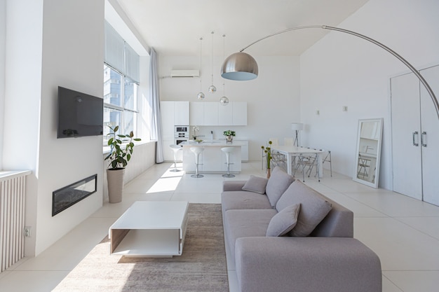 Gemütliches, modernes Luxus-Innendesign eines Studio-Apartments in extra weißen Farben mit modischen, teuren Möbeln im minimalistischen Stil.