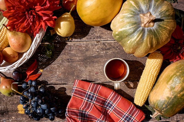 Gemütliches rustikales Stillleben im Herbst Tasse Tee Obst Gemüse Kürbis Birnen Apfel Melone Traube und Mais Thanksgiving Day Konzept mit Platz für Text Ästhetische Gemütlichkeit im Herbst Georgine Blume