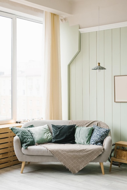 Gemütliches Sofa mit Kissen im Inneren des Wohn- oder Schlafzimmers
