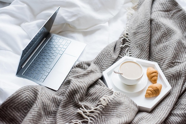 Gemütliches Wochenende zu Hause Laptop und Kaffee im Bett