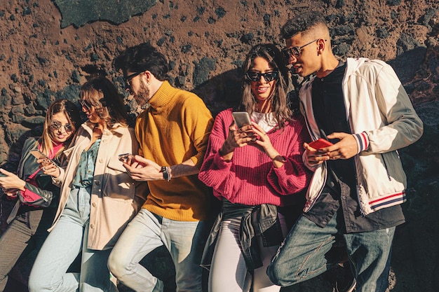 Foto gen z-freunde sorglos reden und surfen social-media-konkurrenz die smartphones - junge leute, die internet-inhalte im freien teilen