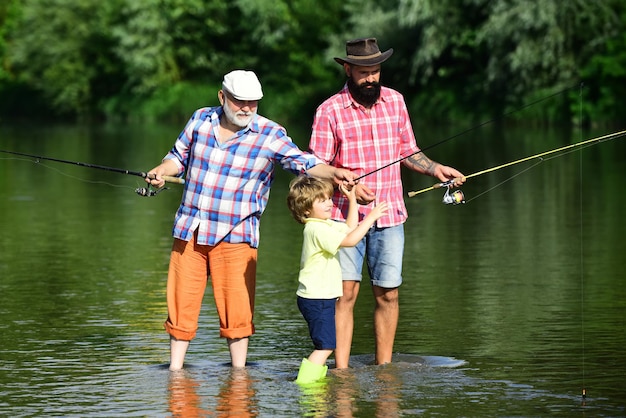 Generación familiar y concepto de personas. Hijo de padre enseñando a pescar con mosca en el río. Hombre en diferentes edades.