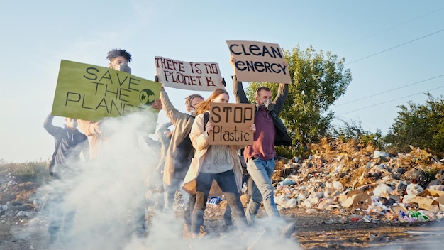 Generation kümmert sich um die ZukunftGruppe von Freiwilligen in Gasmasken mit einem Plakat, das zur Vorsicht aufruft ...