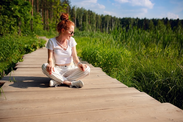 Gengibre encantadora mulher jovem linda verde floresta. Menina caucasiana, relaxando e curtindo a vida na natureza ao ar livre.