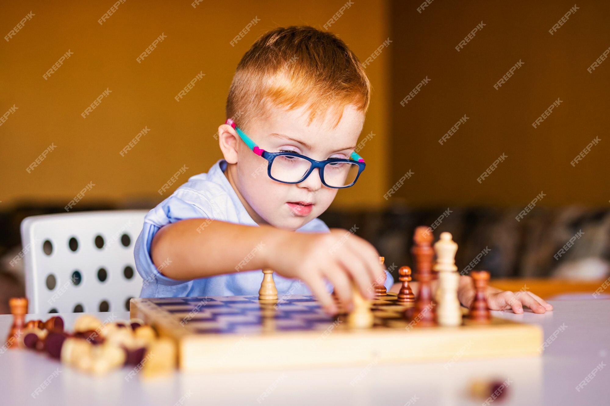 Menino Ruivo Nos óculos Sentado Em Casa E Jogando Xadrez Sozinho