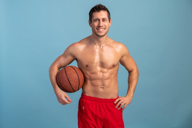 Genial hombre moderno bien formado posando con pelota de baloncesto Cuidado del cuerpo cuidado de la salud pérdida de peso orgullo fuerza liderazgo motivación felicidad autoridad concepto de gimnasio