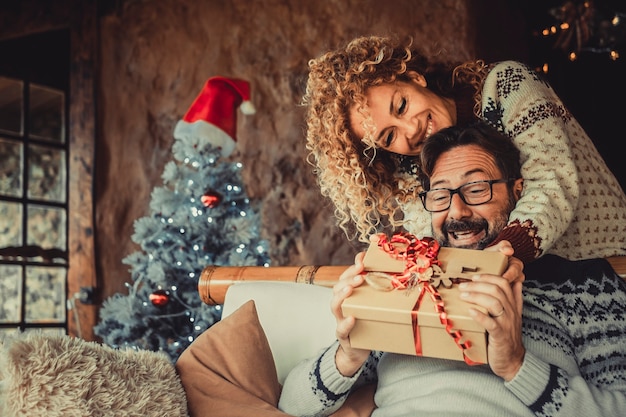 Genossenes Paar zu Hause, das Geschenk für Weihnachtsferien austauscht